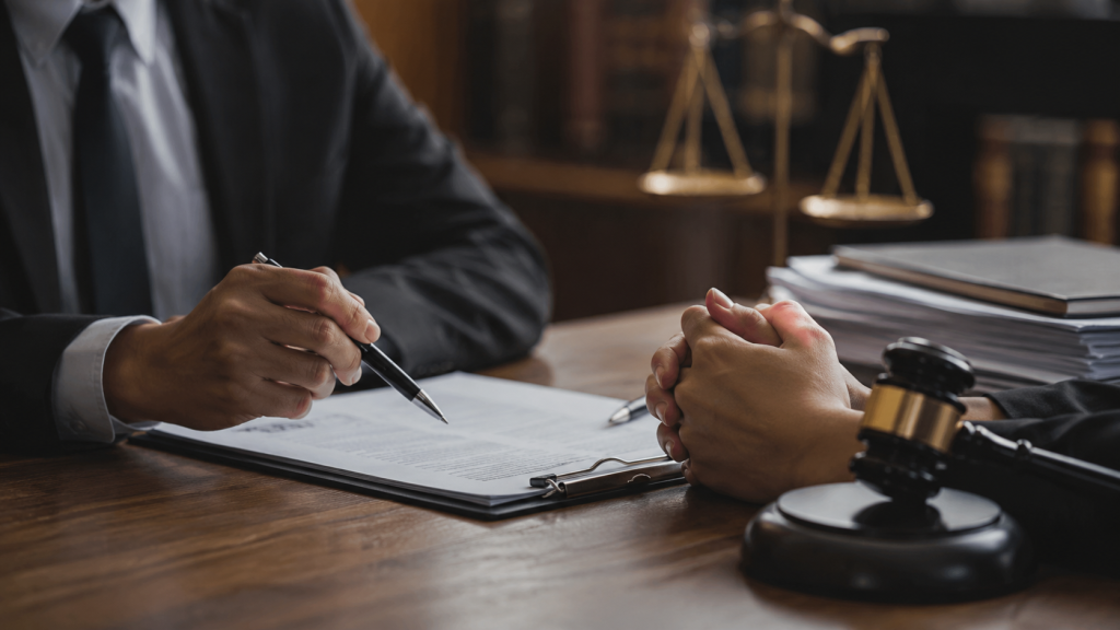 Attorney signing papers beside a gavel