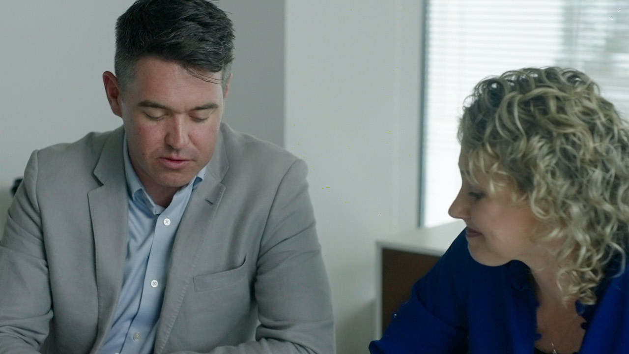 Two people reviewing documents in a meeting
