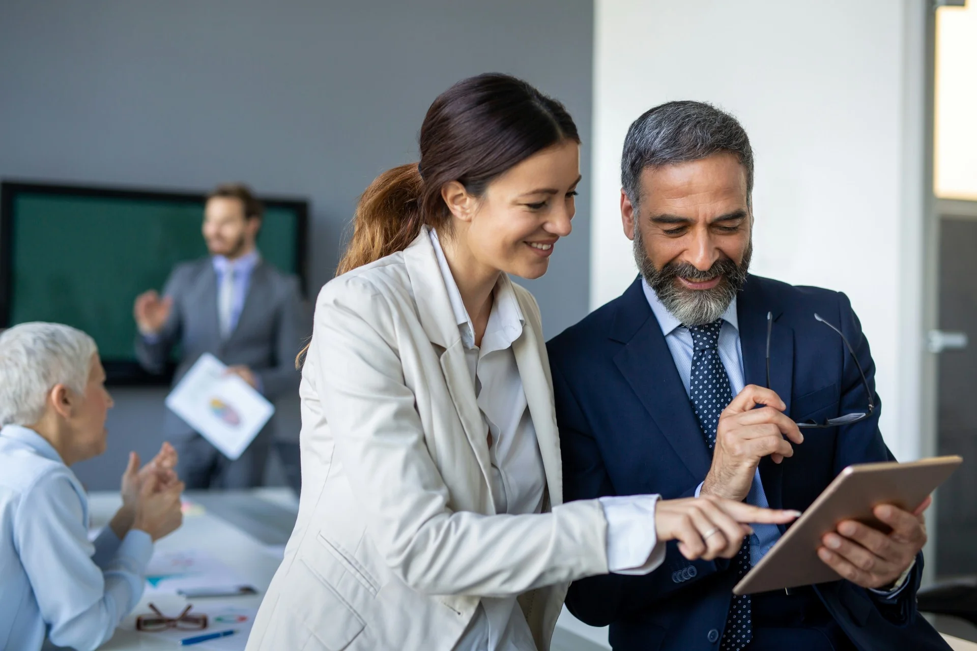 Business professionals reviewing a tablet in a meeting