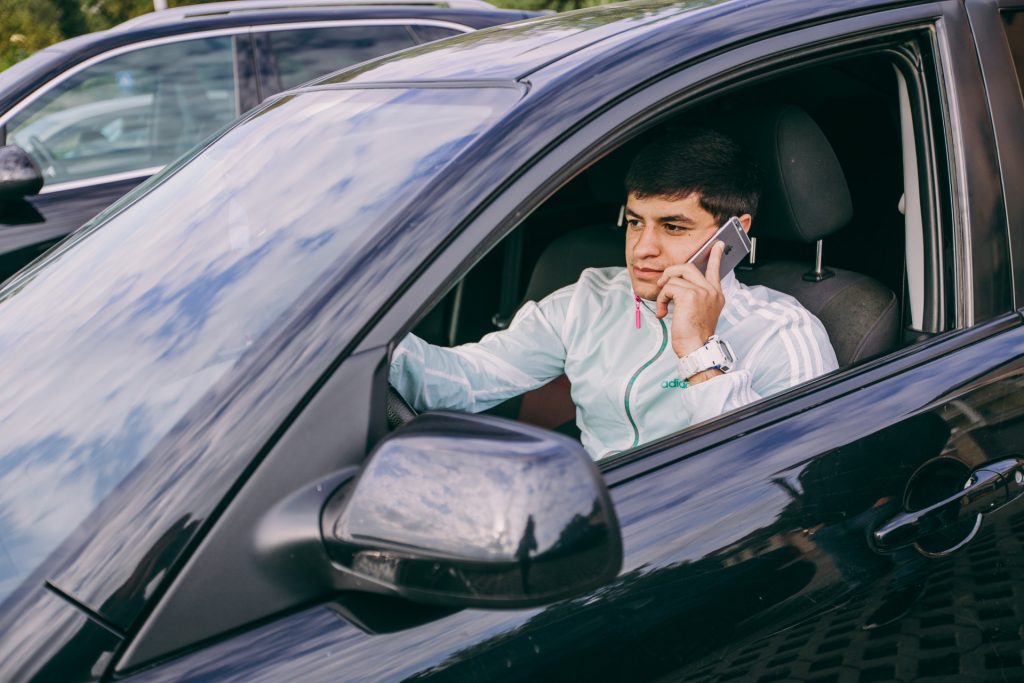 Young driver talking on a phone while driving